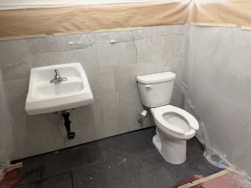Baño comercial terminado: lavabo e inodoro instalados por GD Professional Plumbing